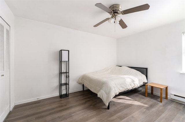 bedroom with baseboards, baseboard heating, and wood finished floors