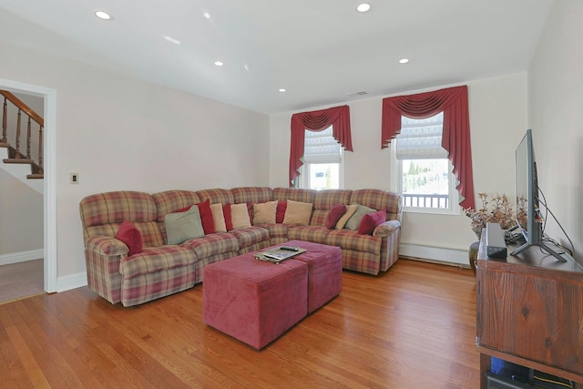 living room featuring light wood finished floors, recessed lighting, stairway, baseboard heating, and baseboards