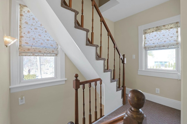 staircase with carpet, plenty of natural light, and baseboards