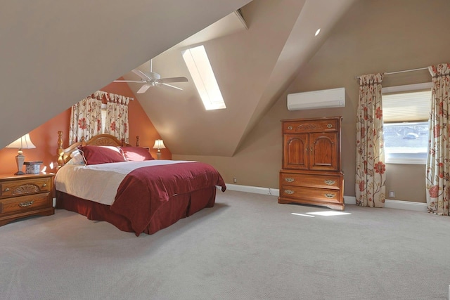 bedroom with light colored carpet, a wall mounted AC, lofted ceiling with skylight, a ceiling fan, and baseboards