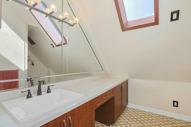 bathroom with vaulted ceiling, vanity, baseboards, and tile patterned floors