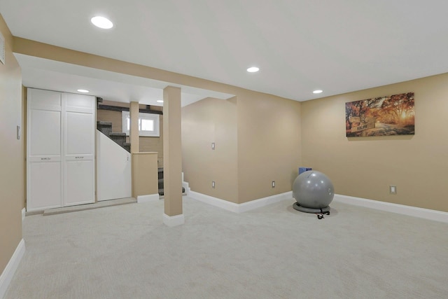 basement featuring recessed lighting, light colored carpet, stairway, and baseboards