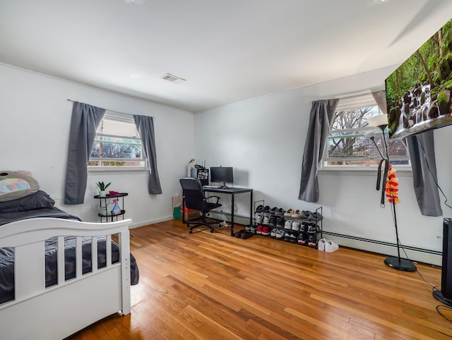 bedroom with visible vents and hardwood / wood-style flooring