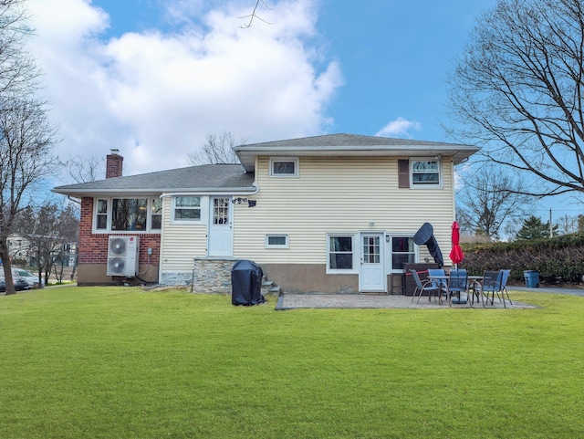 rear view of property with a yard, a patio, and a chimney