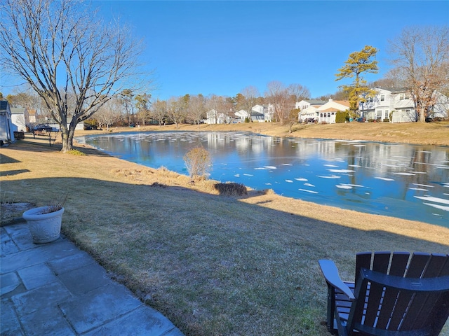 view of yard with a residential view and a water view