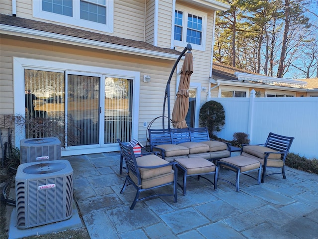 view of patio / terrace featuring outdoor lounge area, fence, and central air condition unit