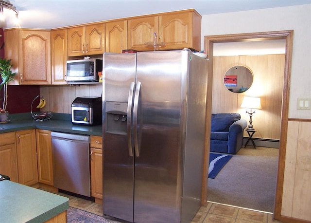 kitchen featuring light carpet, dark countertops, appliances with stainless steel finishes, and baseboard heating