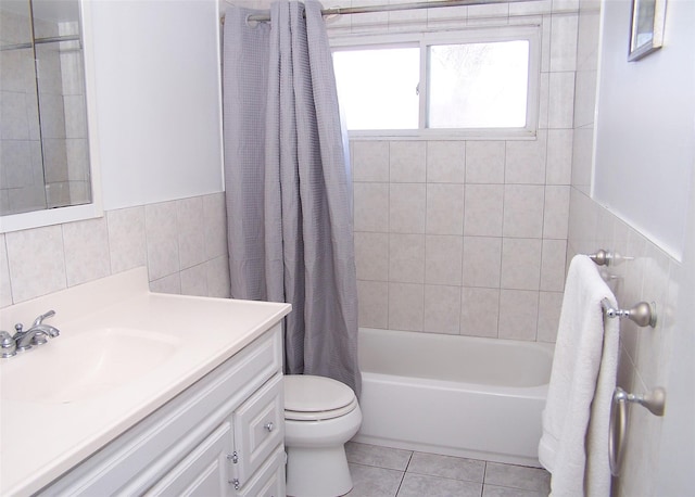 bathroom featuring tile patterned flooring, toilet, vanity, tile walls, and shower / bath combo