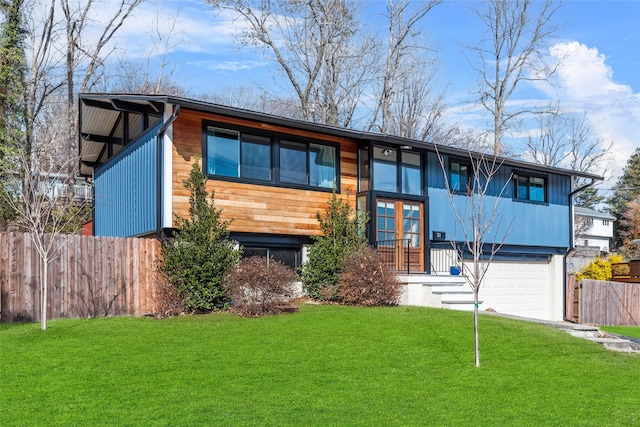 view of front facade featuring an attached garage, a front yard, and fence