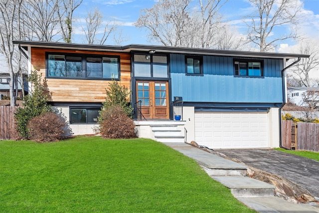 view of front of property with a garage, fence, driveway, french doors, and a front yard