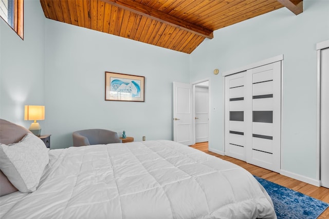 bedroom featuring lofted ceiling with beams, wooden ceiling, baseboards, and wood finished floors