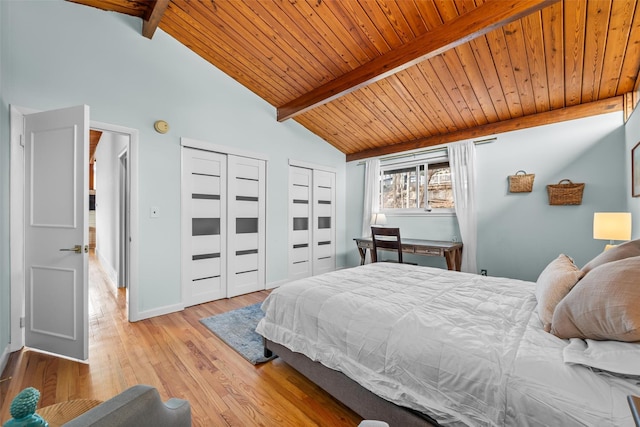 bedroom with wood ceiling, beamed ceiling, two closets, and wood finished floors