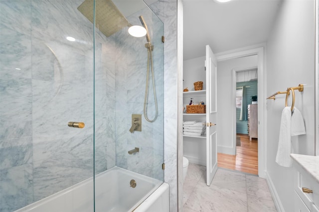 full bath with baseboards, toilet, marble finish floor, combined bath / shower with glass door, and vanity