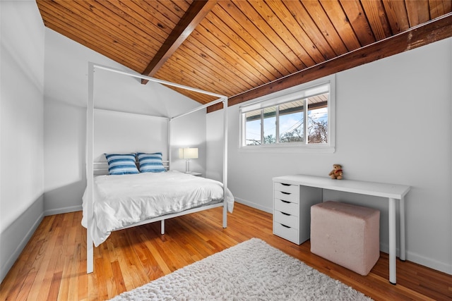 bedroom featuring vaulted ceiling with beams, wood finished floors, and baseboards