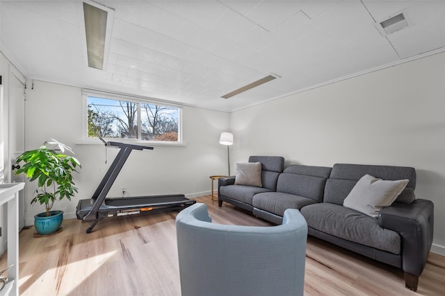 living area featuring baseboards, visible vents, and wood finished floors