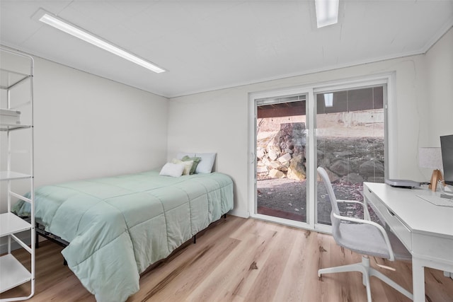 bedroom with access to outside and wood finished floors