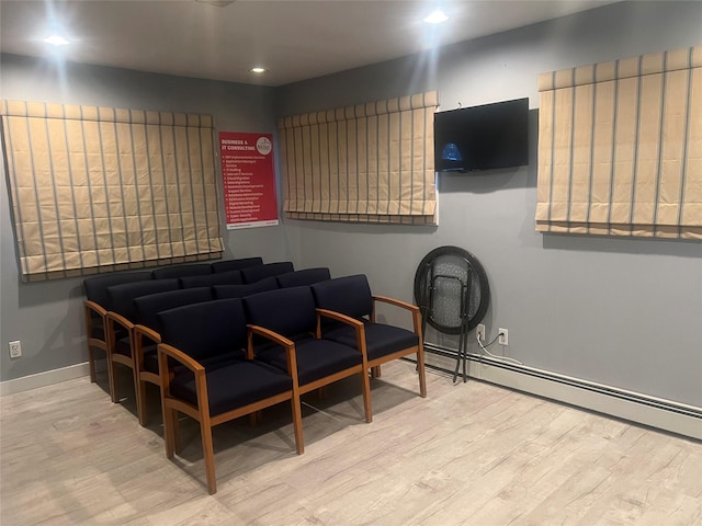 interior space featuring baseboard heating, recessed lighting, baseboards, and wood finished floors