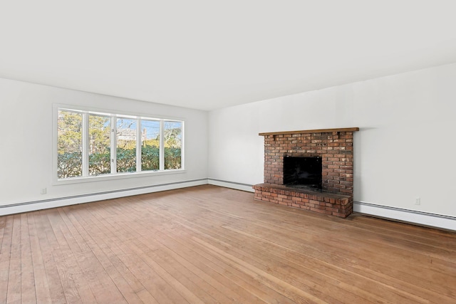 unfurnished living room with hardwood / wood-style flooring, a brick fireplace, and baseboard heating