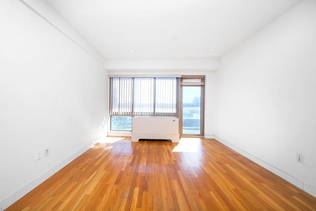 empty room with light wood-style floors and baseboards