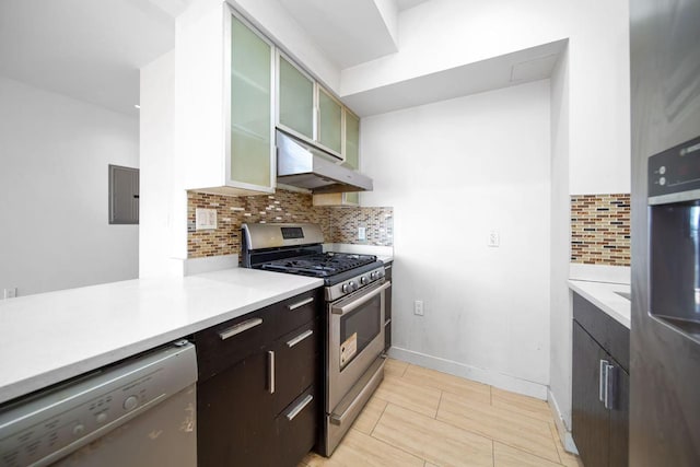 kitchen featuring light countertops, backsplash, glass insert cabinets, appliances with stainless steel finishes, and under cabinet range hood