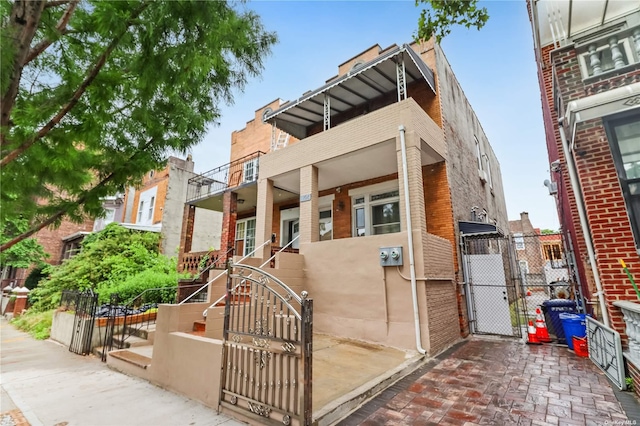 exterior space featuring a gate, brick siding, and fence