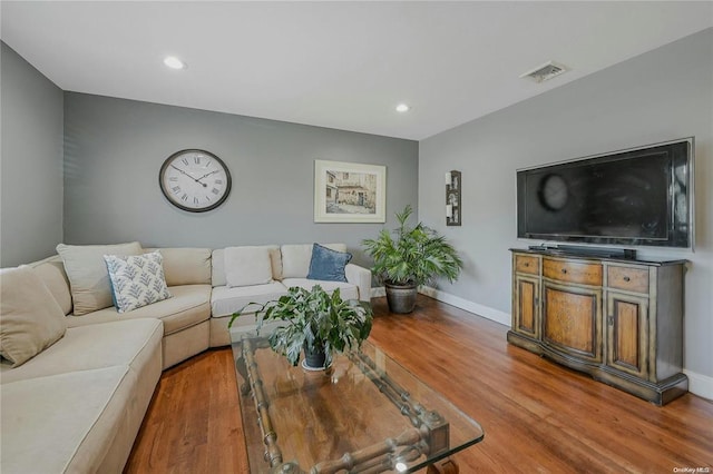 living room featuring recessed lighting, wood finished floors, visible vents, and baseboards