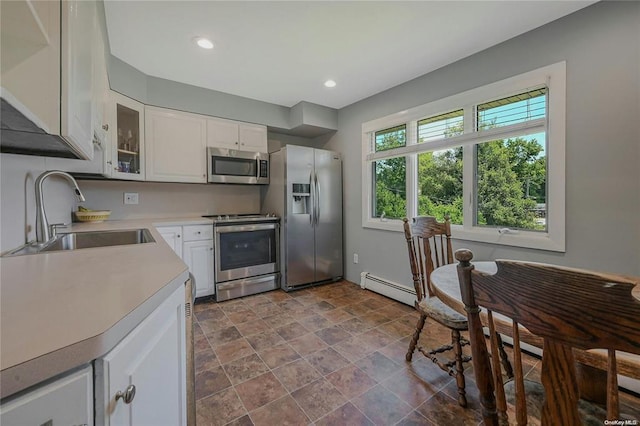 kitchen with white cabinets, glass insert cabinets, appliances with stainless steel finishes, light countertops, and a sink