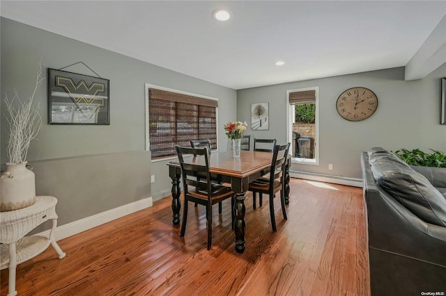 dining space with baseboards, baseboard heating, wood finished floors, and recessed lighting