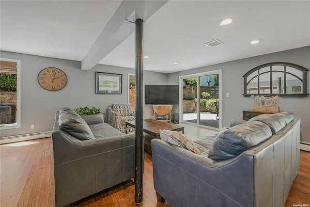 living area featuring visible vents, baseboard heating, wood finished floors, and beamed ceiling