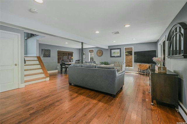 living area with recessed lighting, wood finished floors, visible vents, baseboards, and stairs