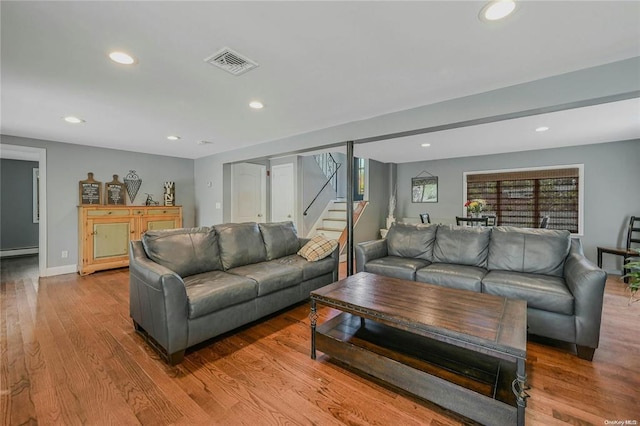 living area featuring recessed lighting, visible vents, stairway, a baseboard heating unit, and wood finished floors