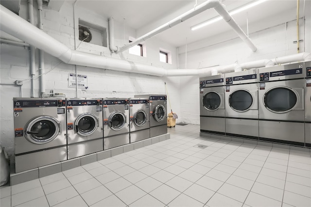 community laundry room featuring light tile patterned floors and washing machine and dryer