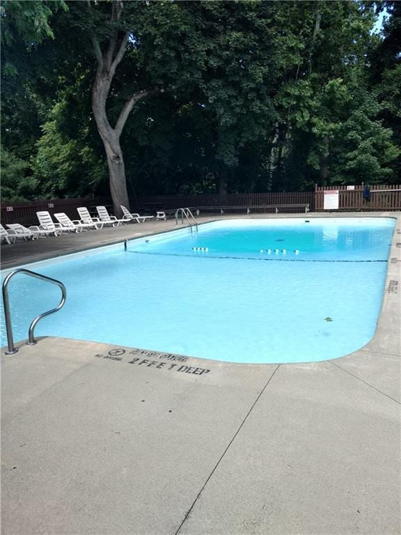 pool with a patio and fence