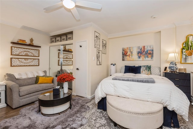 bedroom featuring baseboards, wood finished floors, a ceiling fan, and crown molding