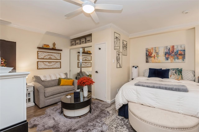 bedroom with baseboards, a ceiling fan, wood finished floors, crown molding, and a closet