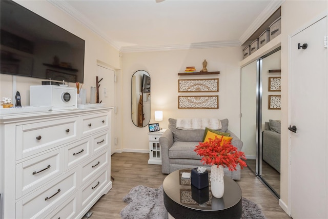 sitting room with light wood-style floors, baseboards, and ornamental molding