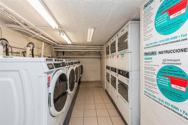 common laundry area featuring a textured ceiling, light tile patterned flooring, washer and dryer, and stacked washer / drying machine