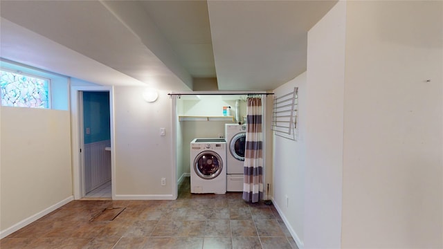 clothes washing area with laundry area, baseboards, and independent washer and dryer