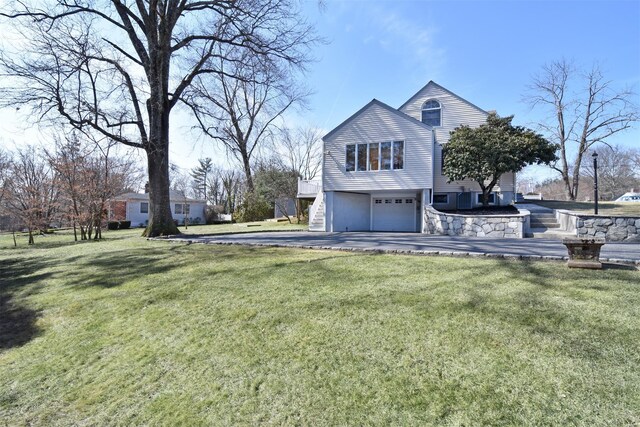 view of side of home featuring a yard, stairway, and a garage