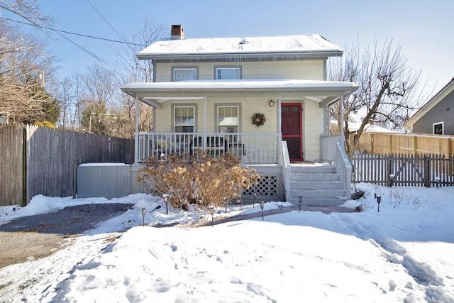 view of front of home featuring covered porch and fence