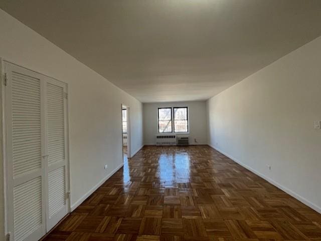 spare room with radiator heating unit and baseboards