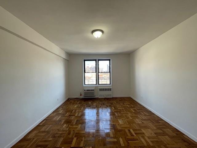 empty room featuring baseboards and radiator heating unit