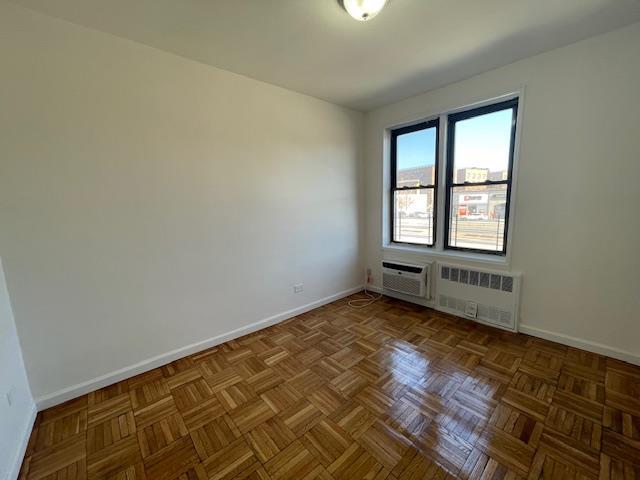 unfurnished room with radiator and baseboards