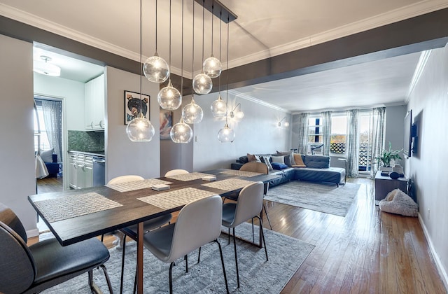 dining space featuring ornamental molding, plenty of natural light, and wood finished floors