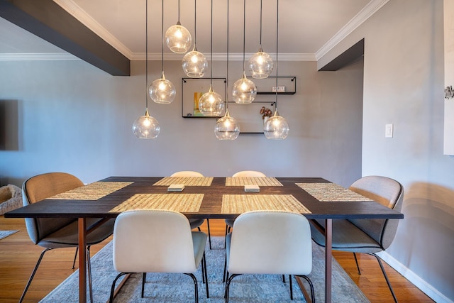 dining room featuring baseboards, wood finished floors, and crown molding