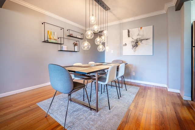 dining space with ornamental molding, baseboards, and wood finished floors