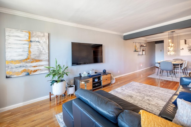 living room featuring crown molding, baseboards, and wood finished floors