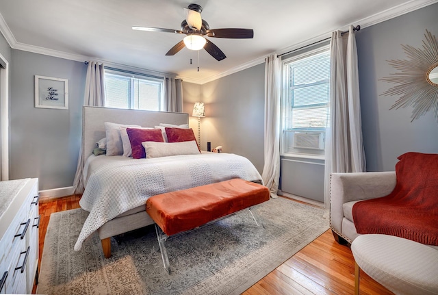 bedroom with ornamental molding, multiple windows, and light wood-style flooring