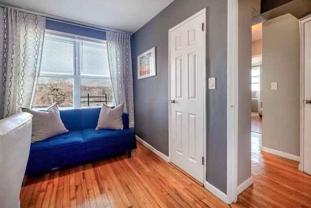 living area with light wood-style flooring and baseboards