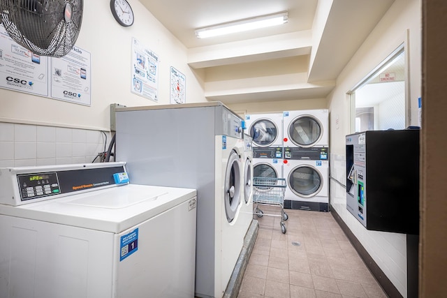 community laundry room featuring stacked washer and dryer and washing machine and clothes dryer